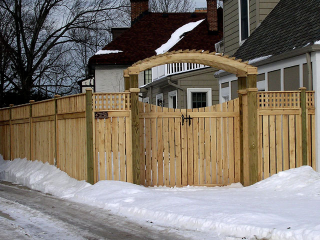 wood arbor with a gate & semi-privacy wood fence by Elyria Fence